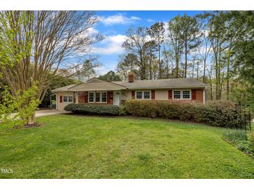 Cozy ranch-style home features red shutters, brick accents, and a well-manicured front lawn at 407 W Cornwall Rd, Cary, NC 27511