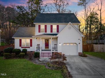 Charming two-story home with red shutters, inviting front porch, and attached garage, perfect for suburban living at 409 Machost Dr, Garner, NC 27529