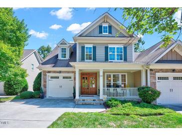 Charming two-story home with a stone and siding exterior, covered porch, and well-manicured front yard at 44 Grandwood Cir, Durham, NC 27712