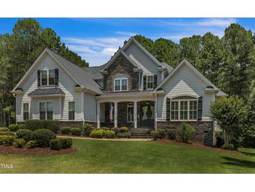Charming two-story home featuring stone accents, landscaped front yard and inviting covered front porch at 45 Calabria Ct, Clayton, NC 27527