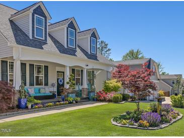 Charming two-story home with dormer windows, lush landscaping, and inviting front porch at 49 Everwood Dr, Four Oaks, NC 27524