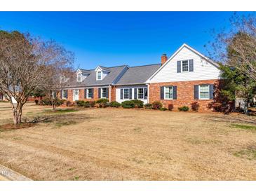 Charming one-story brick home with a manicured lawn and beautiful landscaping at 504 W Brocklyn St, Benson, NC 27504