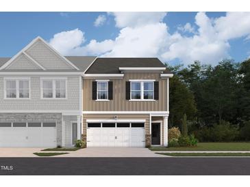 Charming two-story townhome features an attached garage and beautifully landscaped front yard at 6960 Doddridge Ln # 15, Cary, NC 27519