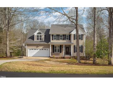 Charming two-story home with a two-car garage, dark shutters, and manicured landscaping at 765 Carlton St, Clayton, NC 27520