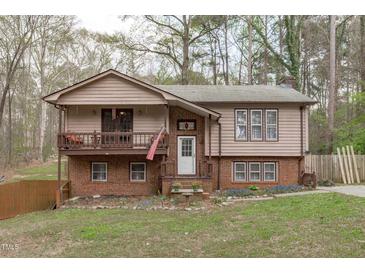 Charming two-story home featuring a cozy front porch, brick accents, and landscaped yard at 900 Stoneybrook Dr, Sanford, NC 27330