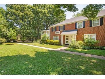 Two story red brick building with manicured lawn and mature trees at 907 St Marys St, Raleigh, NC 27605