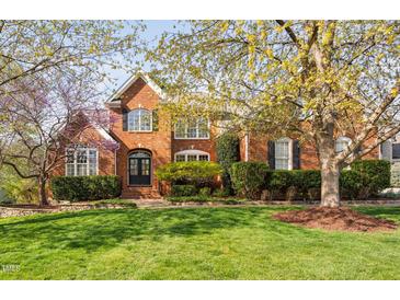 Charming brick home with a manicured lawn and mature trees in full bloom at 9320 Teton Pines Way, Raleigh, NC 27617