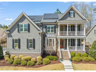 Two-story home with gray siding, solar panels, black shutters, and manicured landscaping at 113 Bennett Mountain Trce, Chapel Hill, NC 27516