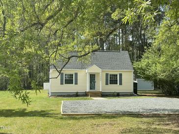 View of charming one story home with well-manicured lawn and mature trees at 1306 Ed Cook Rd, Durham, NC 27703