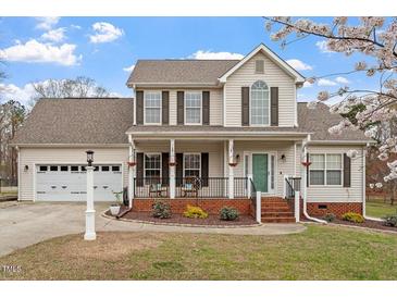 Charming two-story home with a well-manicured lawn, attached garage and inviting front porch at 15 Longwood Dr, Youngsville, NC 27596