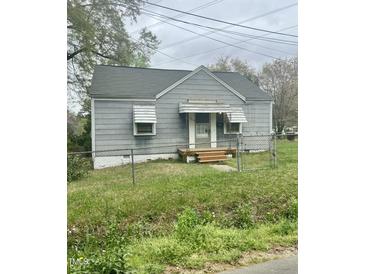 Charming single-story home featuring a gray exterior, fenced front yard, and inviting front porch at 1609 Evergreen St, Durham, NC 27703