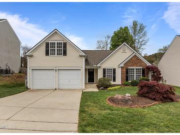 Charming home featuring well-maintained landscaping, a two-car garage, and classic architectural details at 203 Grassy Point Rd, Apex, NC 27502