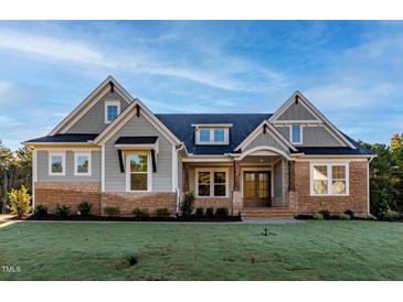 Beautiful home with a stone and siding exterior, lush lawn, and inviting front entrance at 229 Gilliland Rd, Siler City, NC 27344