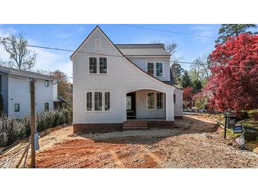 Charming two-story home featuring light-colored siding, black trim windows, and an inviting covered entryway at 2605 Hazelwood Dr, Raleigh, NC 27608