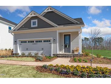 Charming home featuring a brick pathway, two-car garage, and a welcoming front porch area at 293 Providence Creek Dr, Fuquay Varina, NC 27526