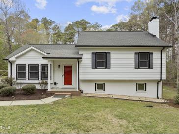 Charming home featuring a bright red front door and mature landscaping at 2949 Tram Rd, Fuquay Varina, NC 27526