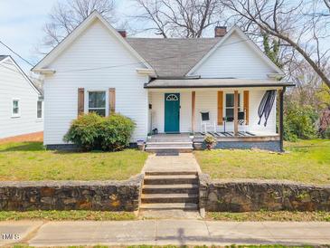 Charming home featuring a quaint front porch and inviting curb appeal with stone retaining wall at 323 W 5Th St, Burlington, NC 27215