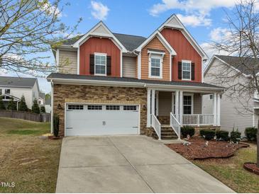 Charming two-story home featuring stone accents, a welcoming porch, and a well-manicured front yard at 3914 Glorybower Way, Apex, NC 27502