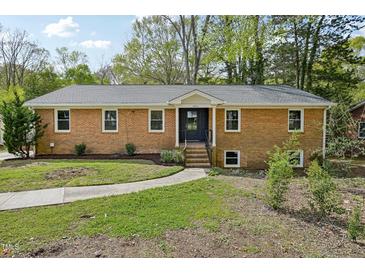 Charming brick home featuring a well-manicured front yard with a walkway to the front door at 4815 Oak Park Rd, Raleigh, NC 27612