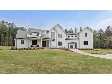 Stunning modern farmhouse with white siding, black trim, and a beautifully landscaped front yard at 482 Emily Ln, Chapel Hill, NC 27516