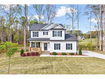 Charming two-story home with a welcoming front porch and beautifully landscaped front yard at 62 Narmada Ct, Zebulon, NC 27597