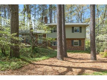 Charming two-story home with a brick facade and a serene wooded setting at 704 Emory Dr, Chapel Hill, NC 27517