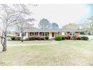 Charming red brick ranch home with a well-manicured front yard and mature landscaping at 808 N Franklin Dr, Sanford, NC 27330