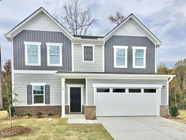 Charming two-story home with a two-car garage and attractive gray and white siding at 829 Kenyon Spring Dr, Zebulon, NC 27597