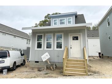 Charming gray home showcasing a welcoming front door and wood stairs, plus bright windows at 905 Linwood Ave, Durham, NC 27701