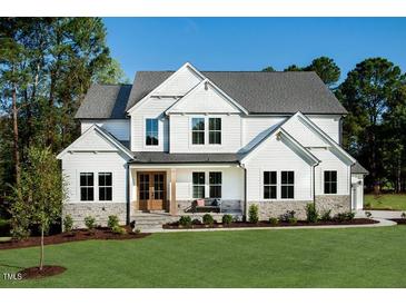 Charming two-story home featuring a beautifully landscaped yard and inviting front porch, perfect for relaxing outdoors at 97 August Trace Dr, Pittsboro, NC 27312