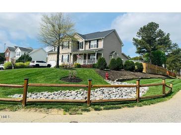 Charming two-story home with a well-manicured lawn and inviting front porch at 10 Sapphire Dr, Sanford, NC 27332
