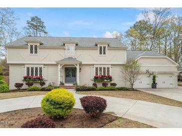 Charming two-story home with gray roof, white trim, and flower boxes under leaded glass windows at 104 Perth Ct, Cary, NC 27511