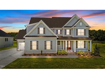 Beautiful two-story home with gray siding, brown shutters, and a well-manicured lawn at twilight at 125 Summerlin Dr, Clayton, NC 27527
