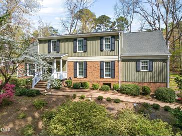 Two-story home featuring a brick and wood facade, complemented by black shutters and a charming landscaped walkway at 1302 Hermitage Rd, Sanford, NC 27330
