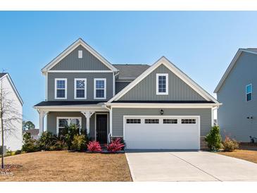 Charming two-story home with gray siding, black roof, manicured lawn, and a two-car garage at 139 Pronghorn Deer Ct, Garner, NC 27529