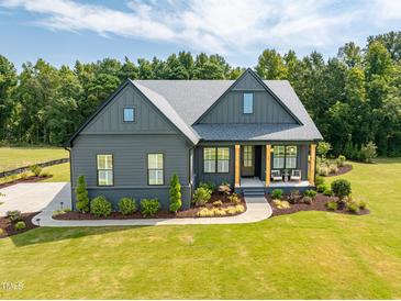 Charming two-story home with a well-manicured lawn and a welcoming front porch, nestled among mature trees at 2108 New Hope Church Rd, Chapel Hill, NC 27514