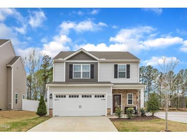 Charming two-story home with gray siding, stone accents, and a two-car garage at 211 Azalea Gaze Dr, Youngsville, NC 27596