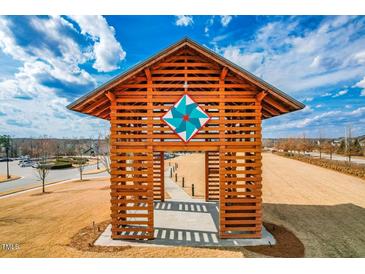 Community wooden pavilion with intricate quilt design provides shade and gathering space at 217 Douglas Falls Dr, Wendell, NC 27591