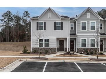 Charming townhome exterior featuring gray siding, stone accents, and well-manicured landscaping at 2456 Tonoloway Dr, Raleigh, NC 27610