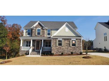 Beautiful two-story home with stone accents, a covered front porch, and manicured landscaping for a welcoming curb appeal at 263 Gilliland Rd, Siler City, NC 27344