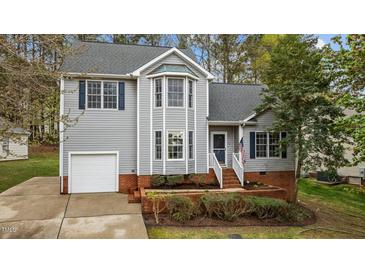 Charming two-story home with gray siding, a well-manicured lawn, and an inviting front entrance at 301 Tillamook Dr, Wake Forest, NC 27587