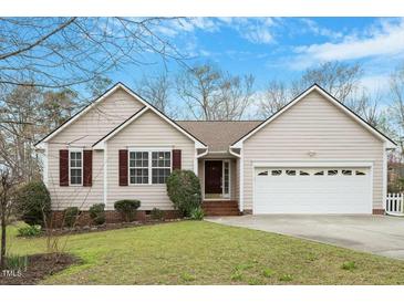 Charming single-story home with neutral siding, red shutters, a well-manicured lawn, and an attached garage at 5604 Stardust Dr, Durham, NC 27712