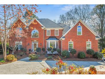 Beautiful two story brick home with manicured landscaping and a circular driveway at 702 Orange Ct, Elon, NC 27244