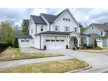 Charming white two-story home with a large driveway and a detached garage at 853 Rambling Oaks Ln, Holly Springs, NC 27540
