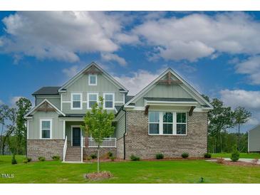 Charming two-story home with brick accents and a beautifully landscaped front yard on a sunny day at Lot 1 Northpointe Farms Trl, Efland, NC 27243