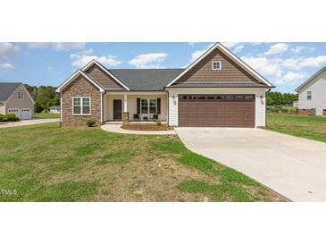 Charming single-story home with stone accents, brown garage door, and well-maintained lawn at 158 Blande Dr, Kenly, NC 27542