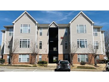 Attractive apartment building featuring light siding, brick accents, and manicured landscaping at 2521 Friedland Pl # 201, Raleigh, NC 27617
