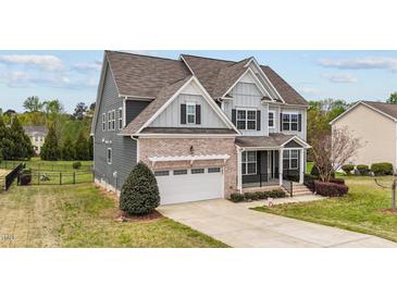 Charming two-story home featuring a brick and siding exterior, attached garage, and well-manicured landscaping at 265 Beckwith Ave, Clayton, NC 27527