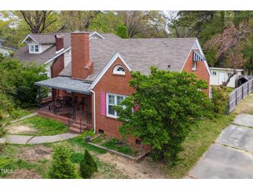 Charming brick home featuring a covered front porch and beautiful landscaping at 2724 N Roxboro St, Durham, NC 27704