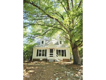 Charming home with dormer windows, black shutters, white trim and siding, and covered front entry at 3421 E E Jameson Rd, Raleigh, NC 27604